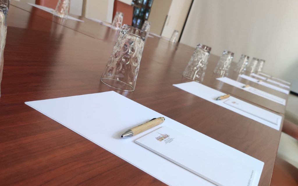 Der Konferenztisch im Rittersaal Deidesheim ist für ein Meeting mit Stiften und Notizblöcken vorbereitet.