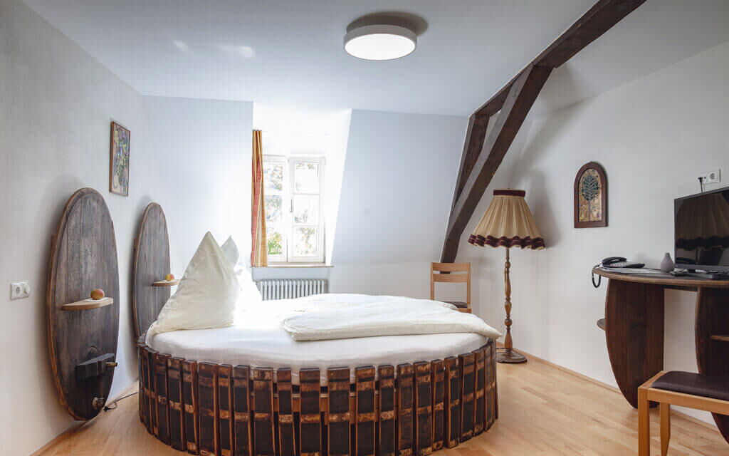 Modernes Hotelzimmer im Hotel Ritter von Böhl mit runder Bettkonstruktion und stilvollem Dekor in Deidesheim.